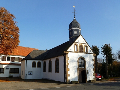 Außenansicht der St.-Anna-Wallfahrtskirche in Hopsten mit weißer Fassade und kleinem Turm