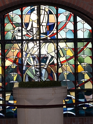 Buntglasfenster mit Taufbecken in der Pfarrkirche St. Mariä Himmelfahrt Schlickelde Buntglasfenster mit Taubendarstellung und Taufbecken in der Pfarrkirche St. Mariä Himmelfahrt Schlickelde