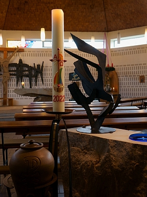 Kirchenraum der St. Hedwig Kirche Lotte mit Osterkerze Innenraum der Kirche St. Hedwig in Lotte mit Osterkerze, modernen Bänken und großem Kruzifix an der Wand